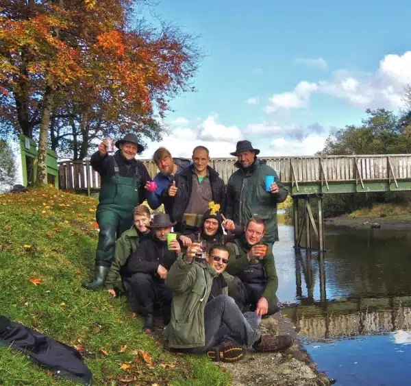 Un groupe de pêcheurs au brochet en Irlande posant sur une petite rivière à killeshandra killykeen forest park